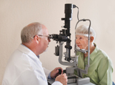 An elderly woman gets her eyes checked.