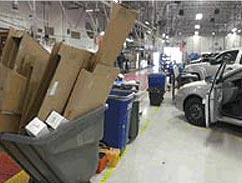 image of flattened cardboard boxes in a gray cart in an automotive factory