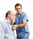 Male doctor listening with stethoscope to patient's heart and lungs