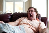 Overweight man napping on sofa