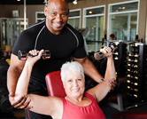 Personal trainer helping a woman lift weights