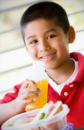 A kid drinks a sweetened drink at lunch