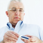 Middle-age man measures his blood glucose level.