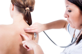 A woman has her skin checked by a dermatologist