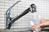 A person fills a glass up with clean water.