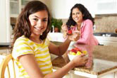 A mother and daughter eat fruit.