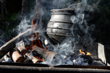 Photo of an iron pot on a smoking fire 